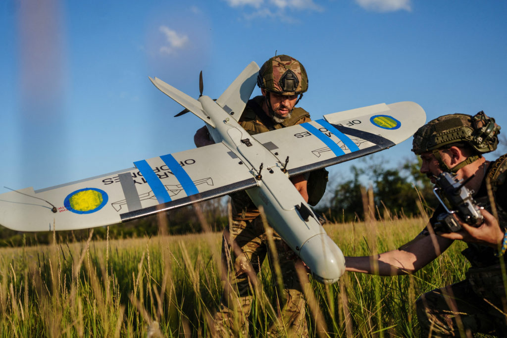 Ukrainian UAV operator carrying a drone in the field